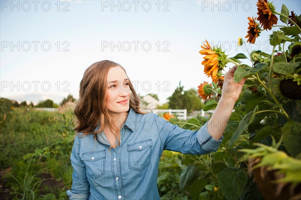 Portrait of young woman harvesting sunflowers. Photo: Jessica Peterson