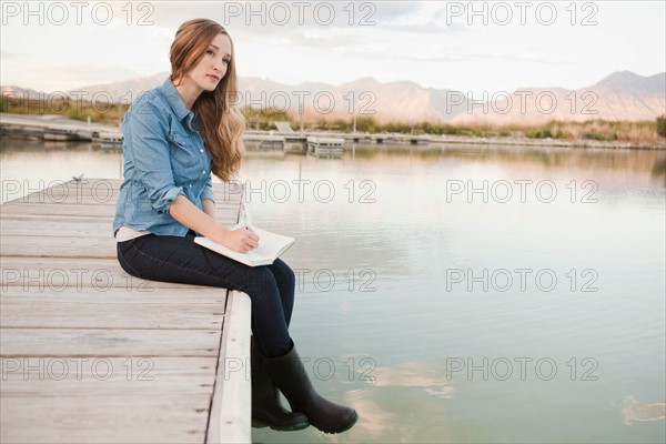 Portrait of young woman sitting on jetty. Photo : Jessica Peterson