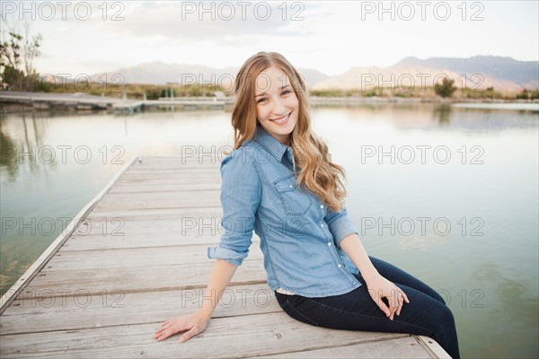 Portrait of young woman sitting on jetty. Photo : Jessica Peterson
