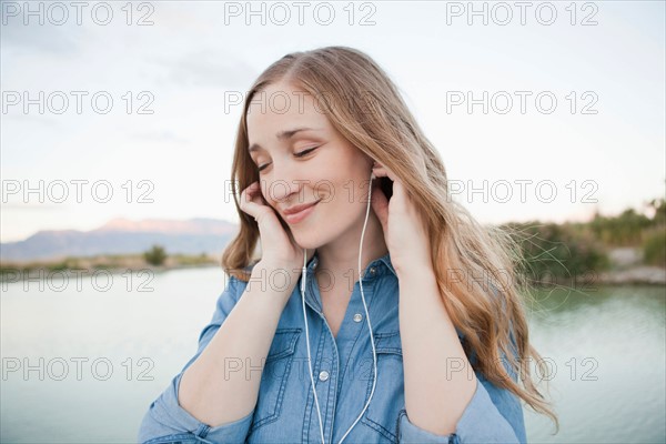 Portrait of young woman listening to mp3 player. Photo: Jessica Peterson