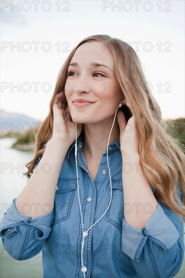 Portrait of young woman listening to mp3 player. Photo : Jessica Peterson