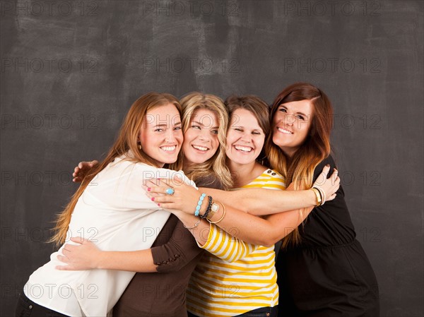 Studio portrait of four women embracing. Photo: Jessica Peterson