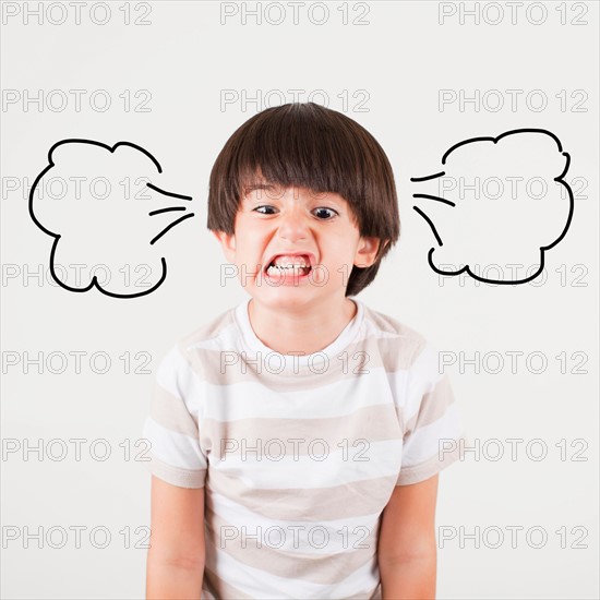 Studio shot of boy (6-7) with smoke puffs coming out of ears. Photo : Jessica Peterson