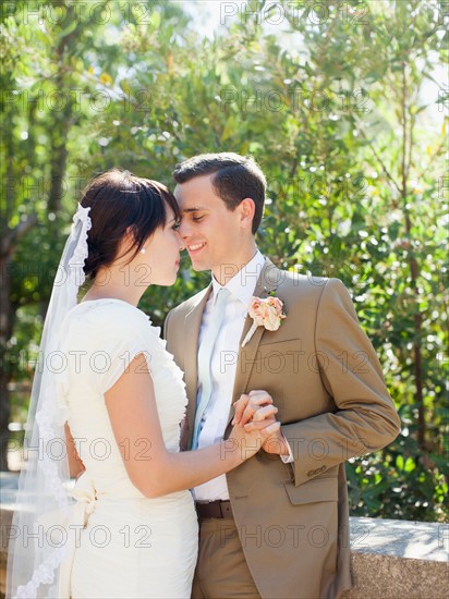 Bride and groom embracing in park. Photo : Jessica Peterson