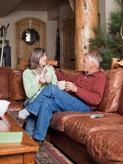 Couple drinking coffee in log cabin. Photo : Jessica Peterson