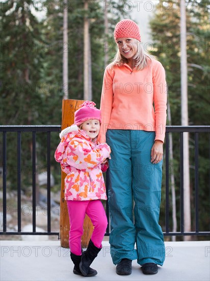 Portrait of mother and daughter (4-5) standing outdoors. Photo: Jessica Peterson