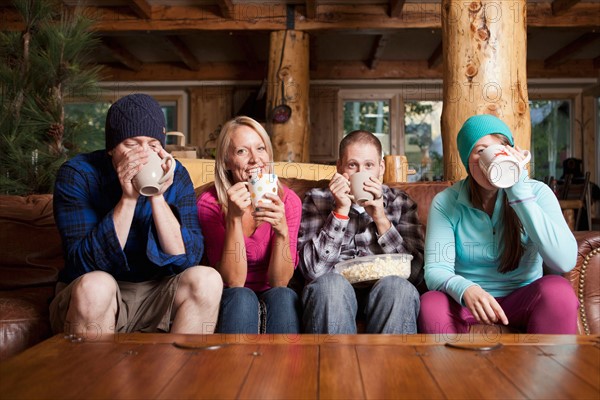 Friends drinking tea in log cabin. Photo: Jessica Peterson