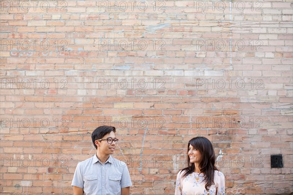 Couple standing in front of brick wall. Photo : Jessica Peterson