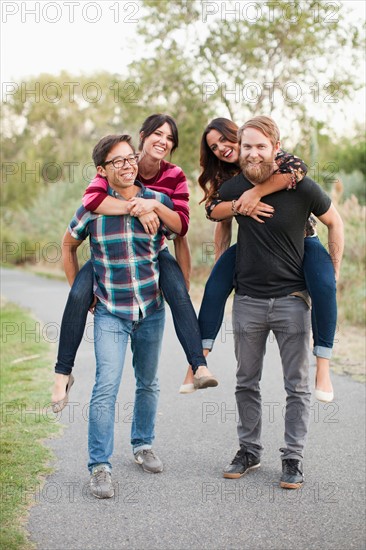 Portrait of group of friends piggy-backing. Photo : Jessica Peterson