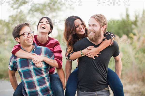 Group of friends piggy-backing. Photo : Jessica Peterson