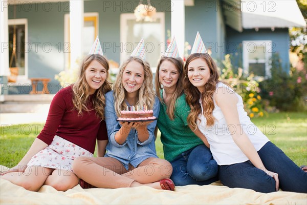 Portrait of four friends with birthday cake. Photo: Jessica Peterson