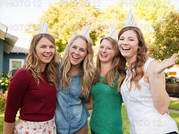 Portrait of four friends wearing party hat. Photo: Jessica Peterson