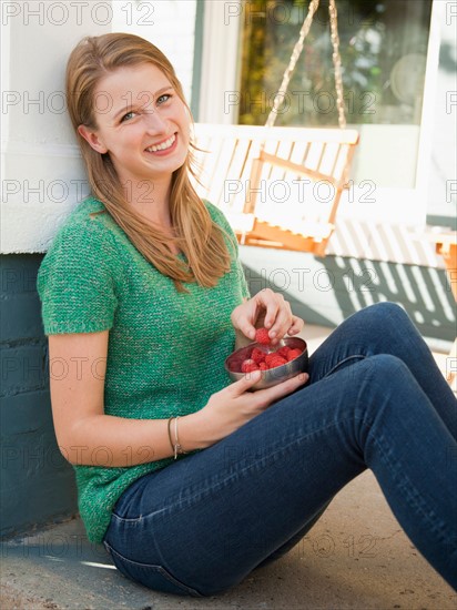 Portrait of young woman eating raspberries. Photo : Jessica Peterson