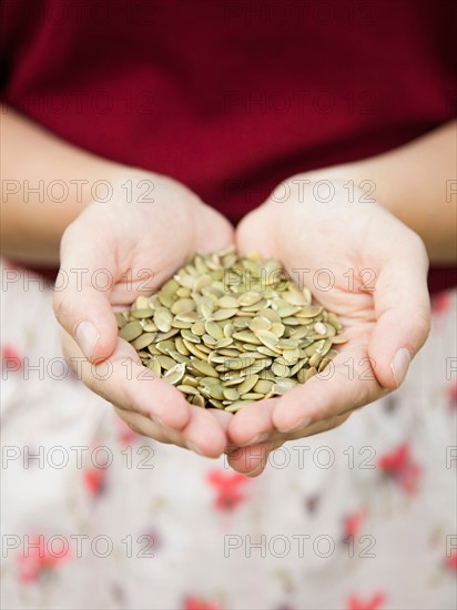 Mid-section of woman holding pumpkin seed. Photo: Jessica Peterson