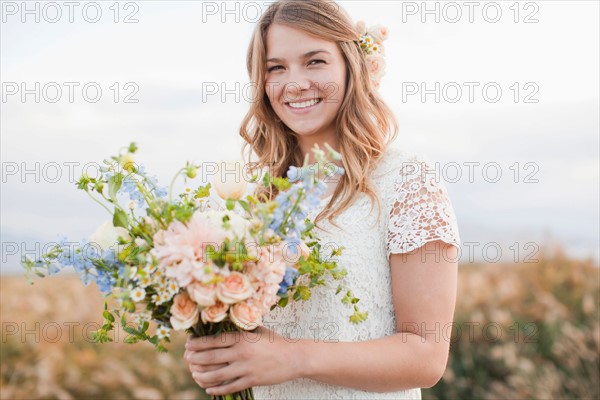 Portrait of bride holding bunch of flowers. Photo : Jessica Peterson