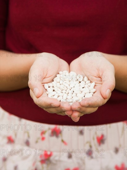 Mid-section of woman holding white beans. Photo : Jessica Peterson