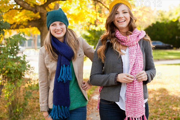 Portrait of two walking young women wearing hats and scarves. Photo : Jessica Peterson
