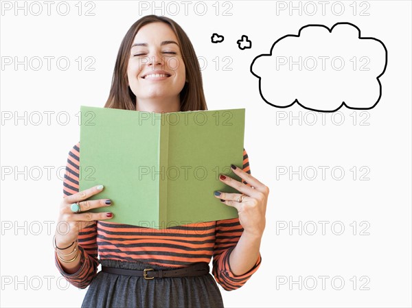 Studio shot young woman holding book with thought bubble next to. Photo: Jessica Peterson