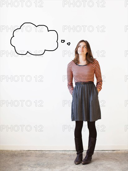 Studio shot young woman looking up on thought bubble. Photo : Jessica Peterson