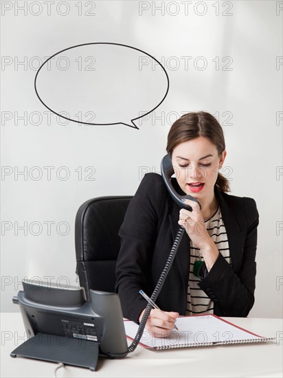 Studio shot of young woman talking on phone with speech bubble next to her head. Photo : Jessica Peterson