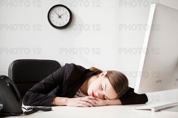 Studio shot of young woman working in office napping. Photo : Jessica Peterson