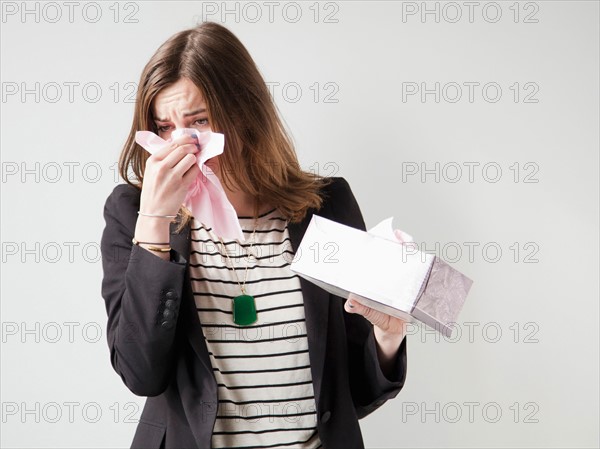 Studio shot of young woman sneezing. Photo : Jessica Peterson