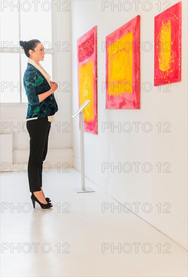 Woman looking at paintings in museum.