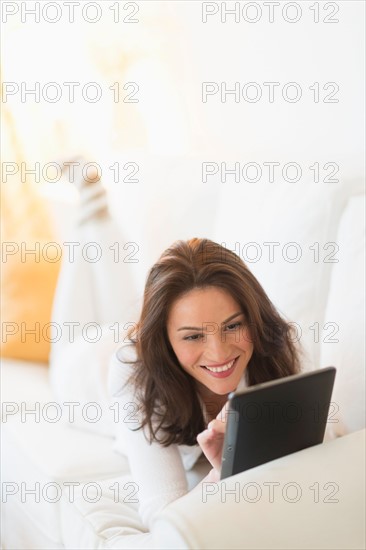 Woman on sofa using tablet pc.