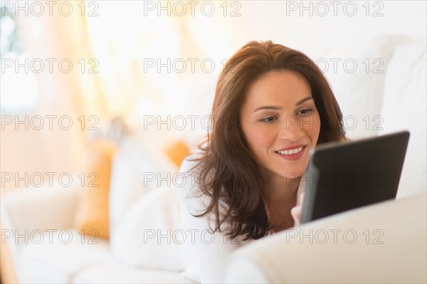 Woman on sofa using tablet pc.