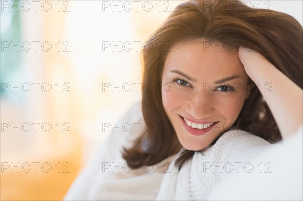 Portrait of woman sitting on sofa.