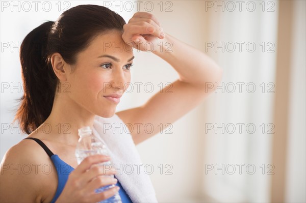 Woman drinking water in gym.