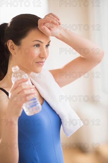 Woman drinking water in gym.