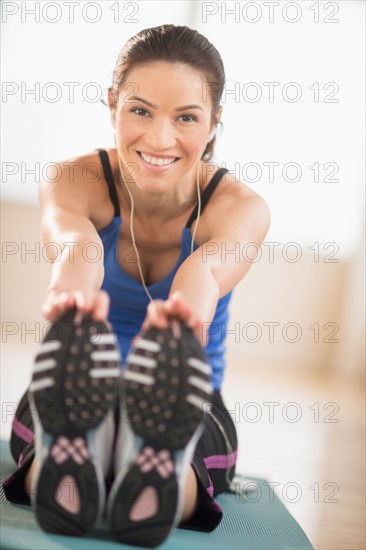 Portrait of woman stretching in gym.