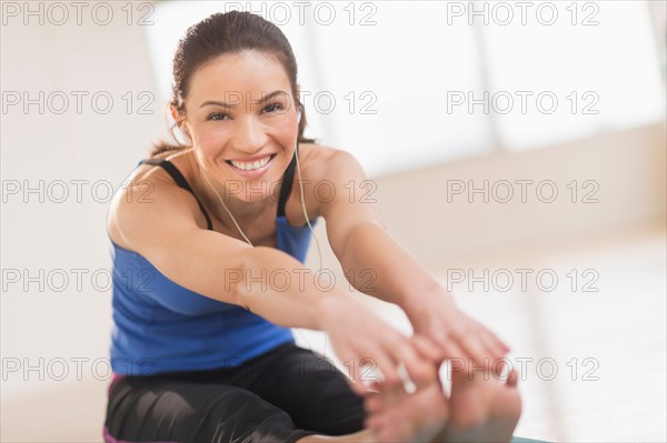 Portrait of woman stretching in gym.