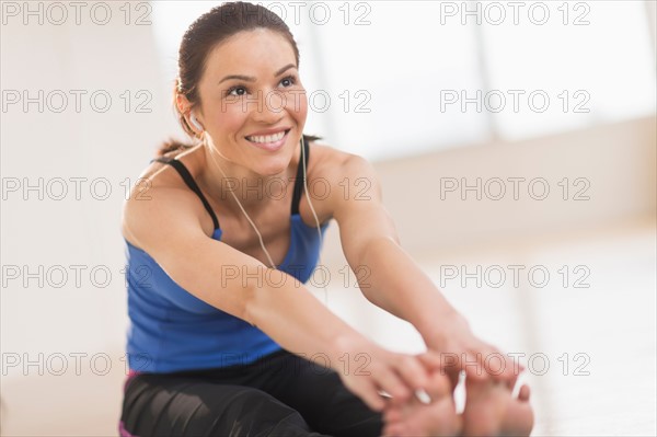 Portrait of woman stretching in gym.