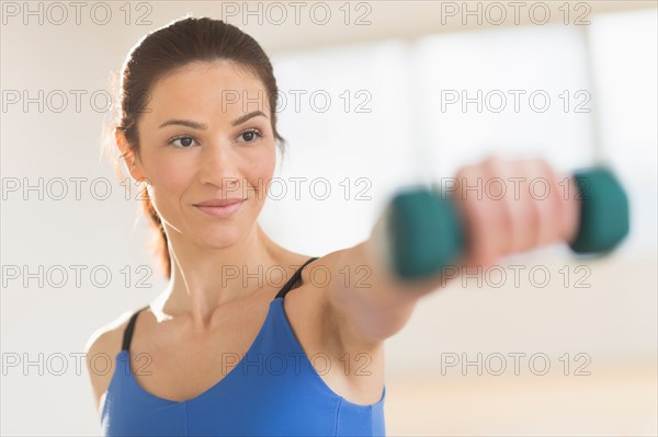 Portrait of woman lifting weights.