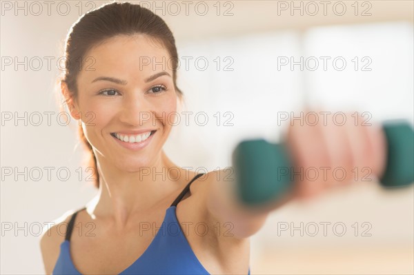 Portrait of woman lifting weights.