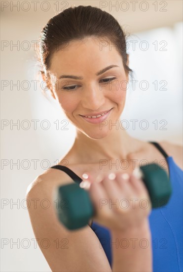 Portrait of woman lifting weights.