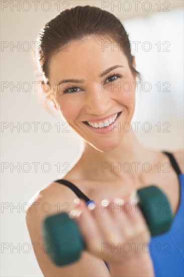 Portrait of woman lifting weights.