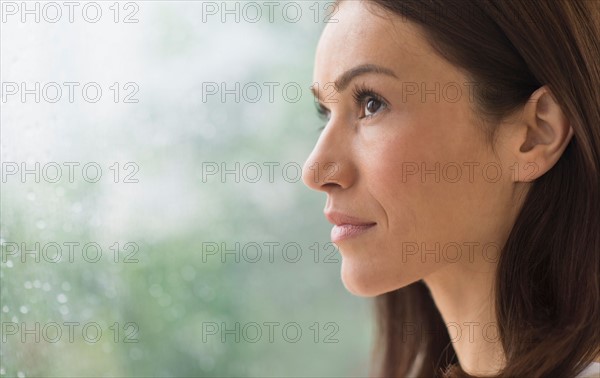 Woman next to rainy window.