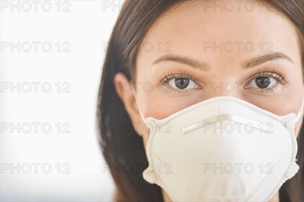 Studio portrait of woman wearing flu mask.