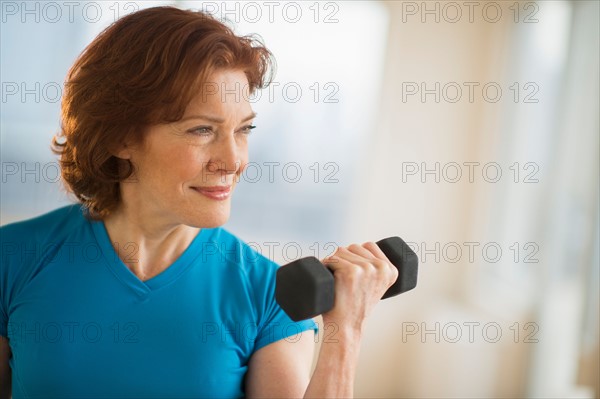 Senior woman lifting weights.