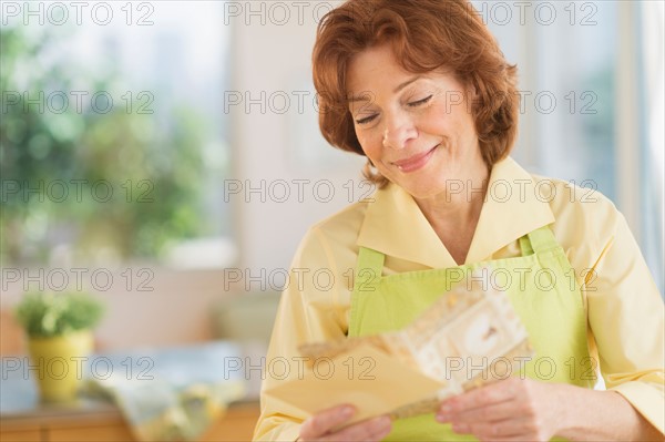 Senior woman reading greeting card.