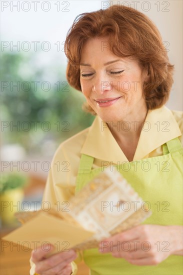 Senior woman reading greeting card.