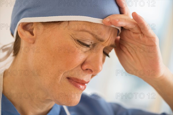 Female surgeon suffering headache.