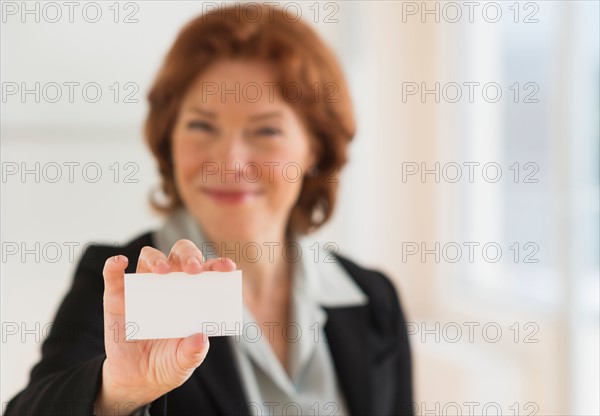 Portrait of businesswoman showing blank business card.
