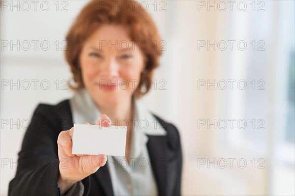 Portrait of businesswoman holding blank business card.