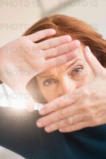 Hands framing face of businesswoman.