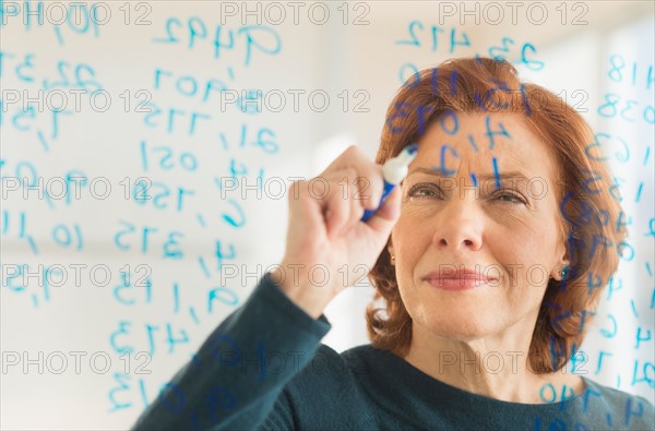 Businesswoman writing on transparent board.