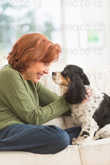 Woman sitting on sofa with dog.